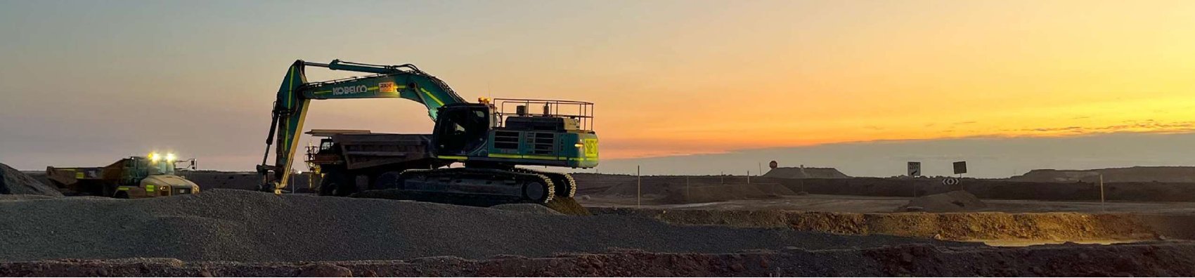 Excavator and dump truck working a Cooper Basin site at sunset